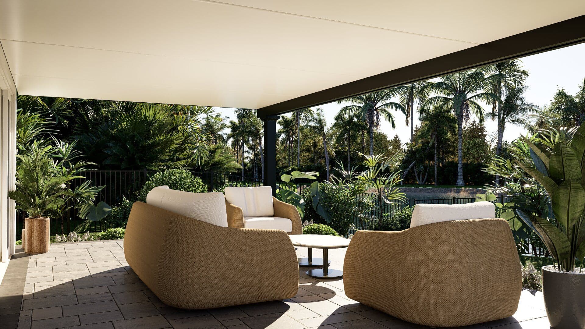 Covered patio with tan woven armchairs, small table, and cream cushioned seating, overlooking lush tropical landscape with palm trees and manicured gardens