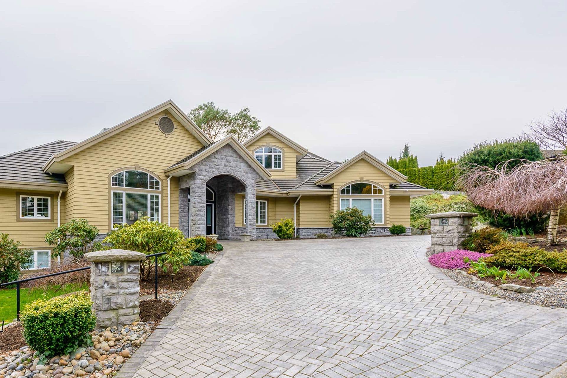 mustard-colored-home-with-long-paved-driveway