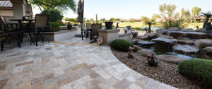 Backyard paver patio with curved edge around landscaping